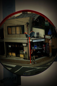 Reflection of man photographing illuminated building