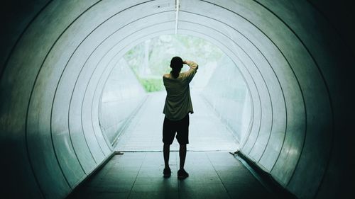 Rear view of man standing in tunnel