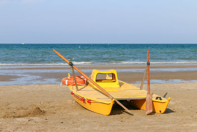 Deck chairs on beach against clear sky