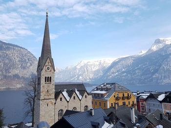 Snow covered buildings and mountains against sky