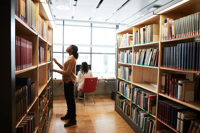 Woman searching book in library