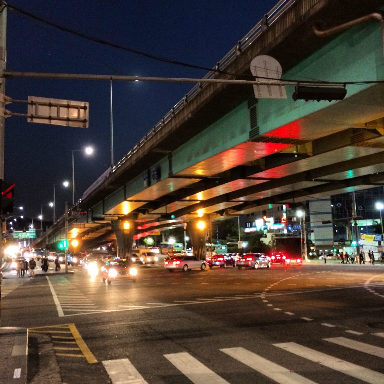 illuminated, transportation, building exterior, architecture, built structure, street, city, night, city life, mode of transport, city street, car, road, land vehicle, street light, incidental people, public transportation, sky, railroad station, railroad station platform