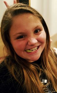 Close-up portrait of girl chewing bubble gum at home