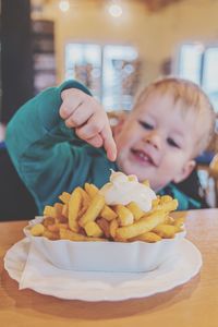 Boy pointing at prepared potatoes in restaurant