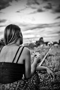 Rear view of woman sitting on beach