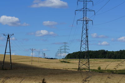 Electricity pylon on field against sky