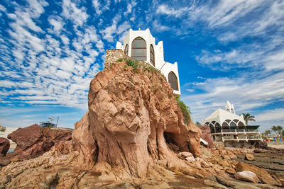 Rock formations on building against sky