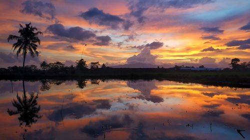 Scenic view of lake against orange sky