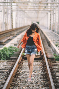 Portrait of young woman standing on railroad station