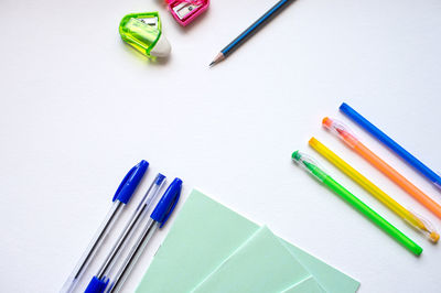 A set of stationery on a white background, pens of different colors.