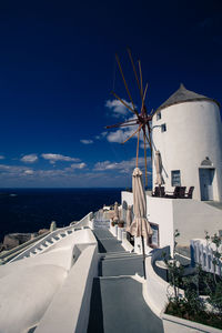 Low angle view of windmill against blue sky at oia