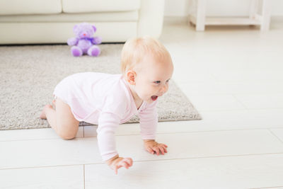 Cute baby girl lying on floor at home