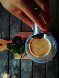 Midsection of person holding coffee cup on table