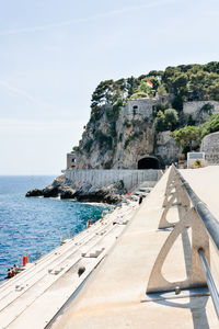 Promenade by sea against sky