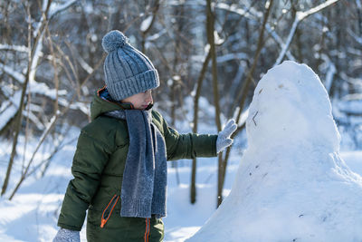 Boy making snowman during winter