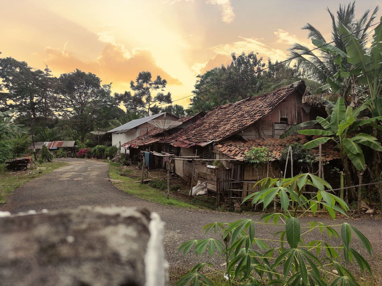 HOUSES BY ROAD AGAINST SKY