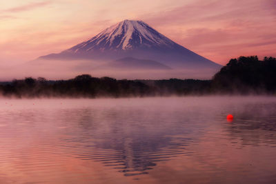 Mountain fuji with reflection and mist on water of lake shoji shojiko at dawn with twilight sky, 