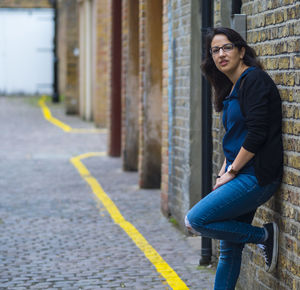 Portrait of woman standing on footpath