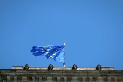 Low angle view of european union flag on building against clear sky