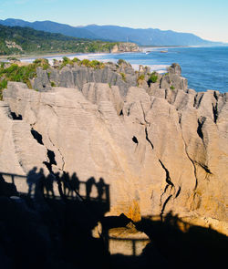 Shadow of people on pancake rocks at punakaiki on sunny day