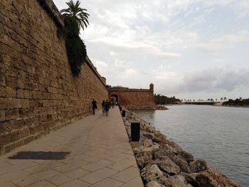 People at historical building against sky