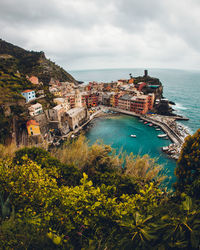 High angle view of townscape by sea against sky