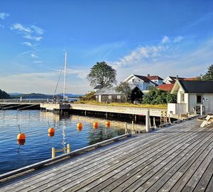 Scenic view of river by buildings against blue sky