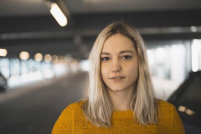 Portrait of smiling young woman standing in underground parking lot