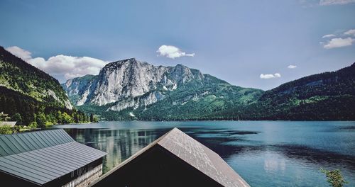 Scenic view of lake by mountains against sky