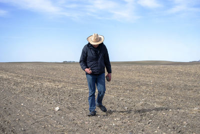 Full length of man standing on field against sky