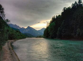 Scenic view of river against cloudy sky