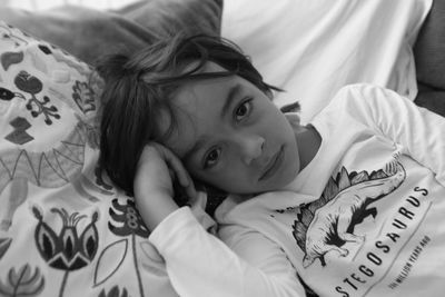 Portrait of cute boy lying on bed at home