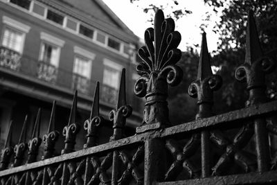 Low angle view of metal gate against sky