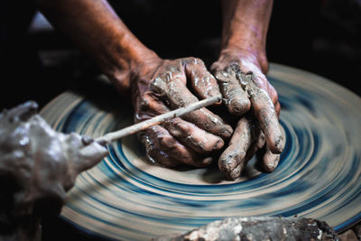 Cropped hands of man working on pottery wheel