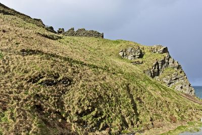 Low angle view of rocks on mountain against sky