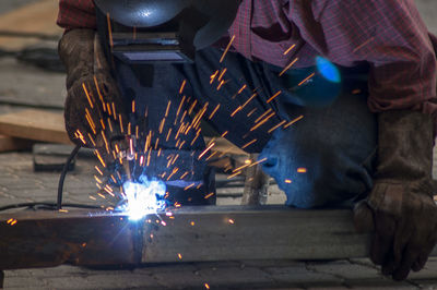 Worker welding metal in workshop