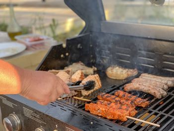 Person preparing food on barbecue grill