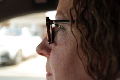 Side view of mature woman wearing eyeglasses in car