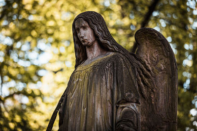 Low angle view of statue against trees