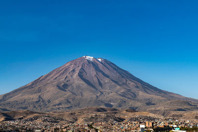 Scenic view of snowcapped mountain against blue sky