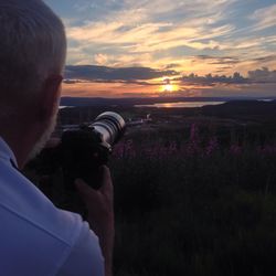 Silhouette of woman on landscape at sunset