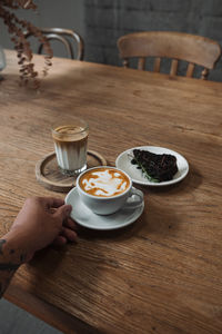 Latte art coffee on wooden table in coffee shop