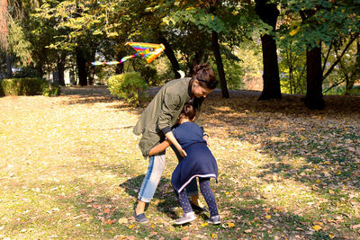 Happy mother and daughter having fun while playing in nature.