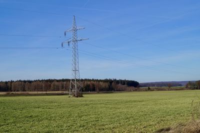 Electricity pylon on field against sky