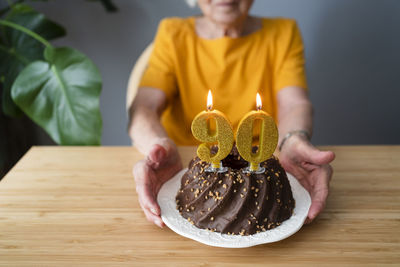 Senior woman with birthday cake sitting at table