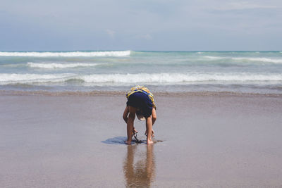 Full length of boy at beach against sky