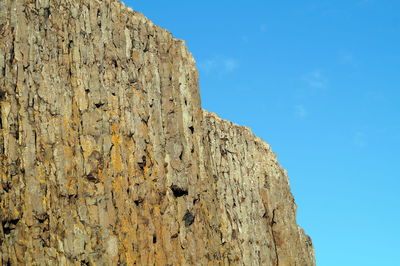 Low angle view of rock formation against blue sky