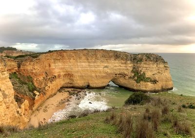 Rock formations by sea against sky