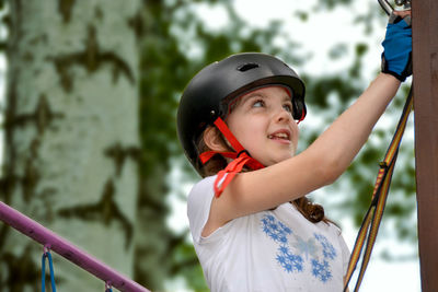 Adventure climbing high wire park - people on course in mountain helmet and safety equipment.