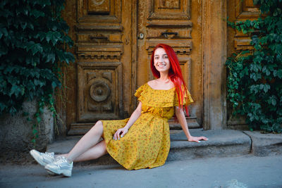 Portrait of smiling young woman sitting outdoors